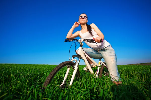 Frau auf der grünen Wiese mit dem Fahrrad — Stockfoto