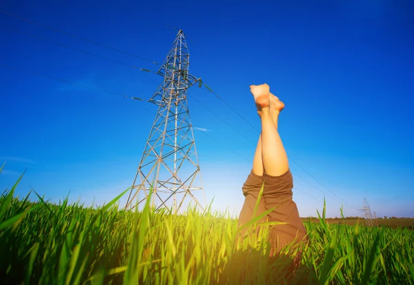 Gambe femminili contro il cielo blu e le linee elettriche — Foto Stock