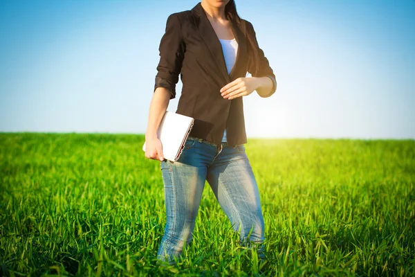 Businesswoman in a green field with a laptop. consept — Stock Photo, Image