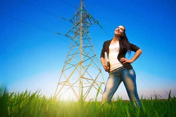 Pretty businesswoman in a field with a laptop. power lines — Stock Photo, Image