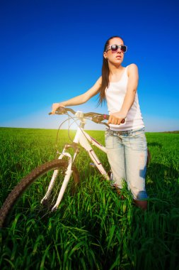 Bisiklet üzerinde yeşil bir alanda sevimli kadın