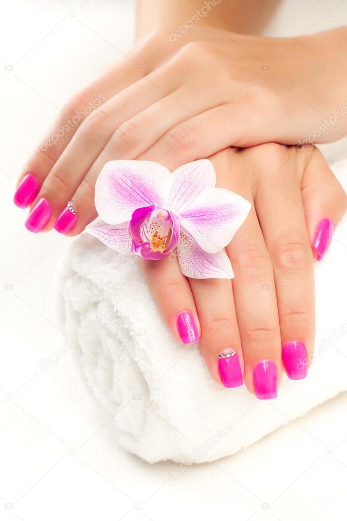Pink manicure with pink orchid and towel