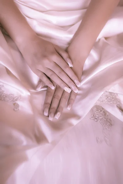 Bruidskamer handen op een witte bruiloft jurk — Stockfoto