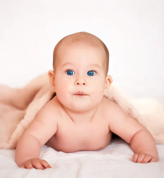 Schattige babymeisje onder de handdoek beige terry — Stockfoto