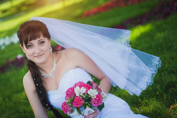 Mariée heureuse en robe blanche dans le parc vert — Photo