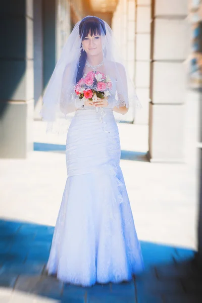 Невеста на синем фоне современного здания — стоковое фото