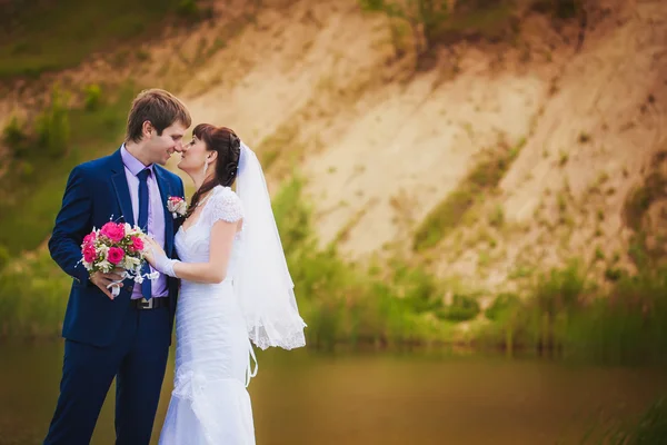 Yeni evliler, göl kenarında sarılıyorlar — Stok fotoğraf