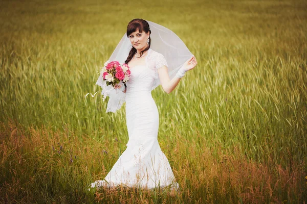 Gelukkige bruid in het groene veld — Stockfoto