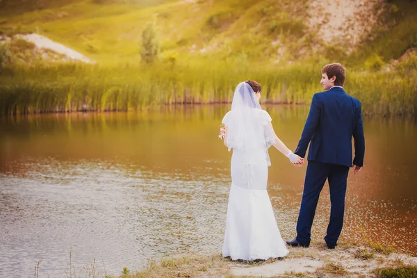 新婚夫婦は、緑豊かな公園にハグします。 — ストック写真
