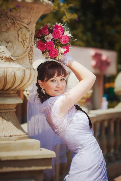 Glad brud nära gamla blomsterrabatt — Stockfoto