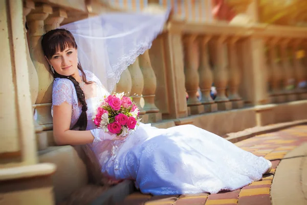 Sposa felice vicino a colonne antiche — Foto Stock