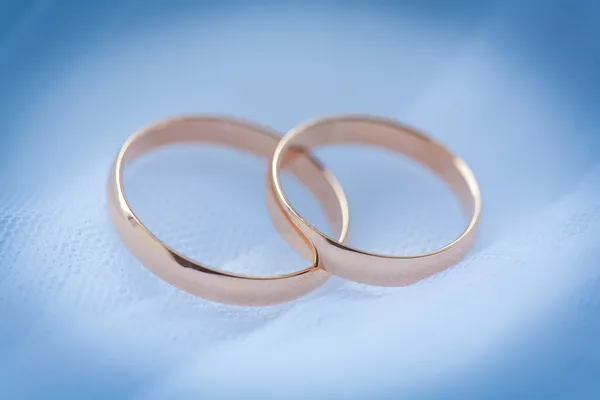 Beautiful golden rings on the blue wedding dress — Stock Photo, Image