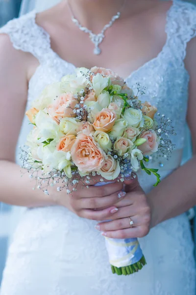 Wedding bouquet in the the bride's hands — Stock Photo, Image