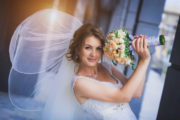 Bride against a blue modern building background — Stock Photo, Image