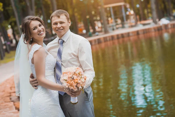 Счастливая невеста и жених в парке — стоковое фото