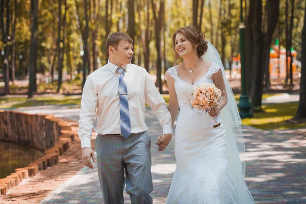 Жених и невеста гуляют по парку — стоковое фото