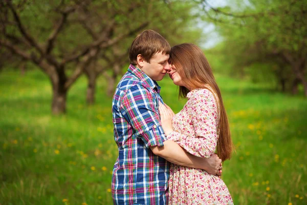 Feliz pareja amorosa abrazándose en un prado de primavera — Foto de Stock