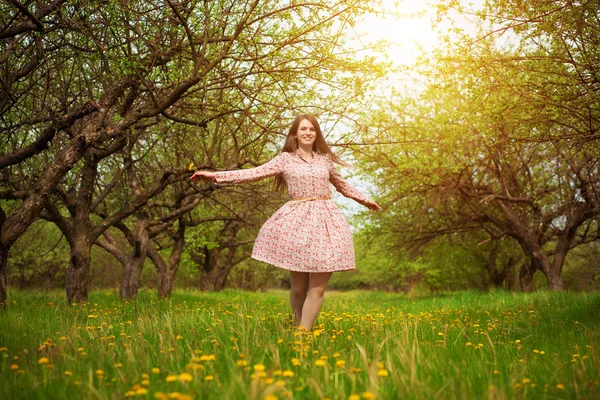 Happy girl is playing on a green spring meadow — Stock Photo, Image