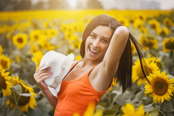 Glad tjej i en solros fält — Stockfoto