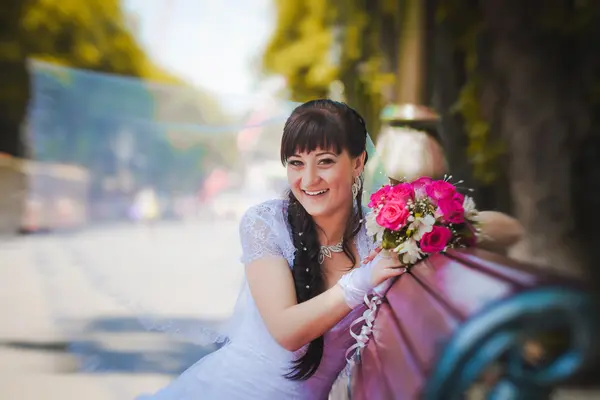 Portrait de mariée heureuse avec un bouquet dans les mains — Photo