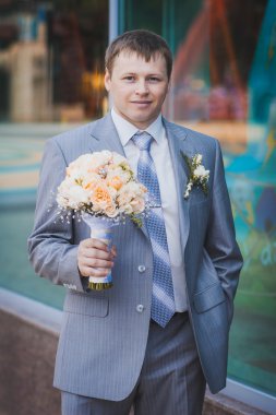 Düğün buketi olan damat.