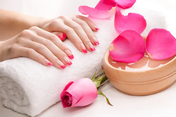 Hands with fragrant rose petals and towel. Spa — Stock Photo, Image