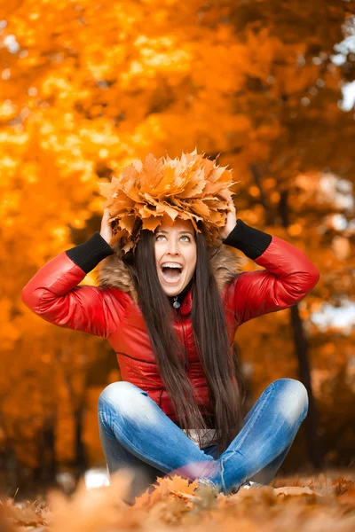 Mujer bonita en una corona de hojas de otoño — Foto de Stock