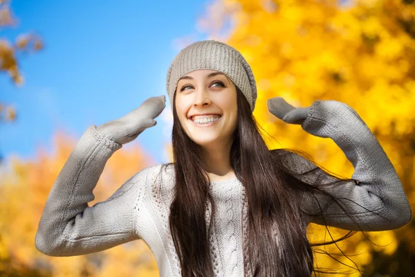 Cheerfu kvinna på en höst himmel bakgrund — Stockfoto