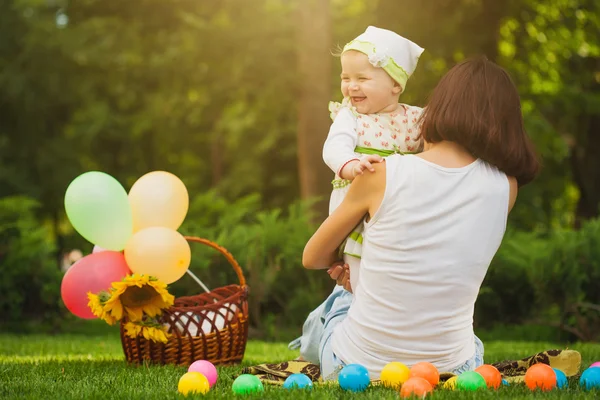 Happy baby and mom are playing in the green park — Stock Photo, Image
