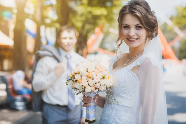 Bruid en bruidegom zitten in het park — Stockfoto