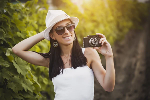 Photographer girl in the rays of the evening sun on the vineyard — Stock Photo, Image