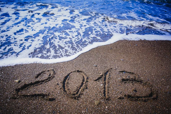 2013 inscription on a beach is washing off by a wave — Stock Photo, Image
