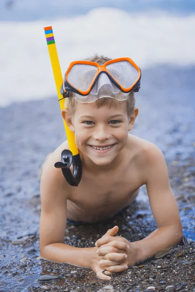 Lycklig pojke driver på stranden — Stockfoto