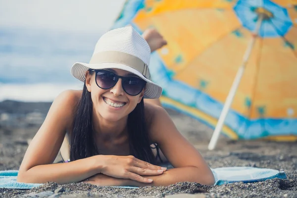 Criança sorridente feliz com computador portátil em uma praia — Fotografia de Stock