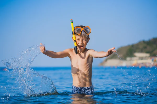 Söt pojke driver på stranden — Stockfoto