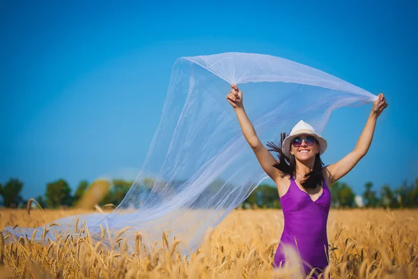Girl is running with shawls on the yellow field — Stock Photo, Image
