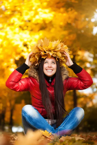 Donna carina in una ghirlanda di foglie di autunno — Foto Stock