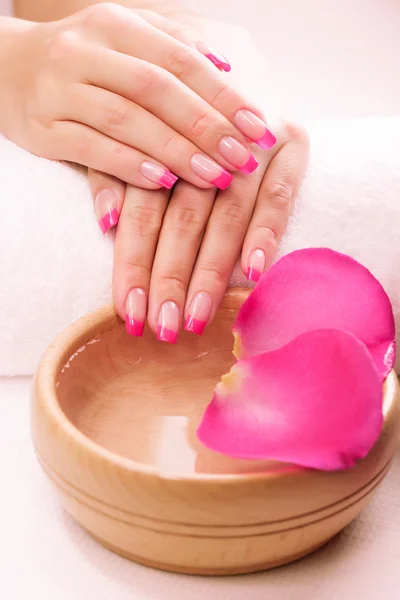 Różowy manicure z pachnących płatków róż i ręcznik. Spa — Zdjęcie stockowe