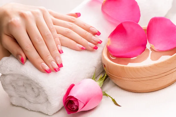 Manicura con pétalos de rosa fragantes y toalla. Spa —  Fotos de Stock