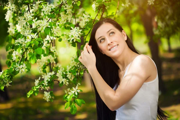 Mooie jonge brunette vrouw in een groen park. zomer — Stockfoto
