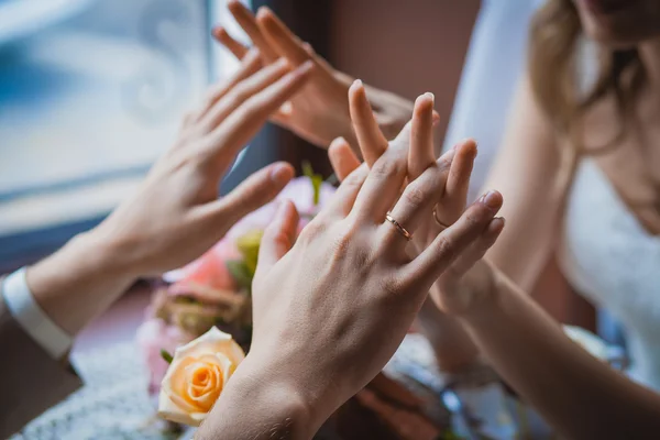 Mains de jeunes mariés et bouquet de mariage — Photo