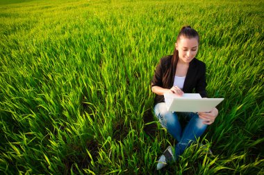 bir dizüstü bilgisayar ile yeşil alan kadın. Yaz