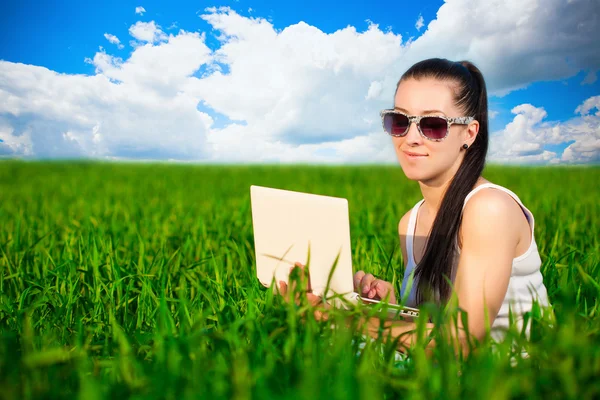 Woman in a green field with a laptop. summer — Stock Photo, Image