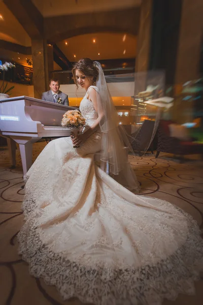 Felizes recém-casados perto do piano — Fotografia de Stock