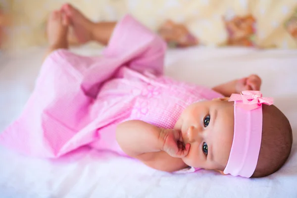 Funny babymeisje in een roze jurk — Stockfoto