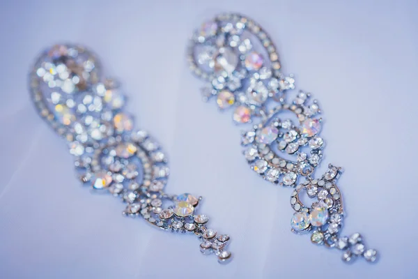 Earrings on a white wedding dress — Stock Photo, Image