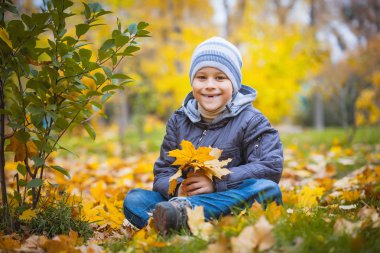 Happy kid on a background of autumn leafs
