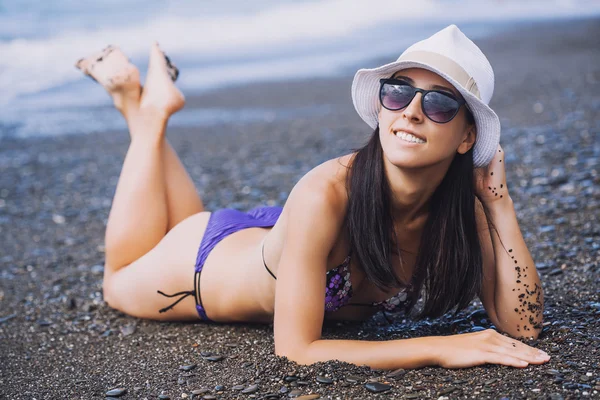 Happy smiling girl is sunbathing on a beach — Stock Photo, Image