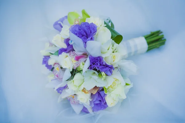 Brautstrauß auf dem blauen Brautkleid — Stockfoto