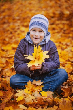 Happy kid on a background of autumn leafs